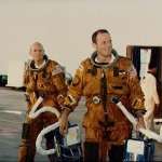 Astronauts Lousma and Fullerton carry portable spacesuit air controllers