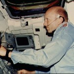 Commander Lousma adjusts HASSELBLAD camera at EEVT on aft middeck